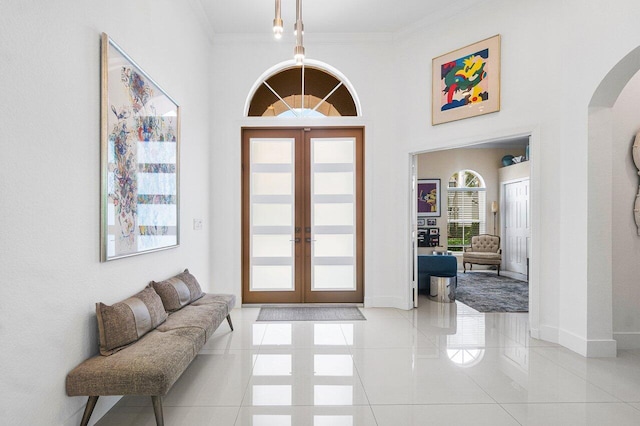 tiled foyer entrance with french doors and crown molding