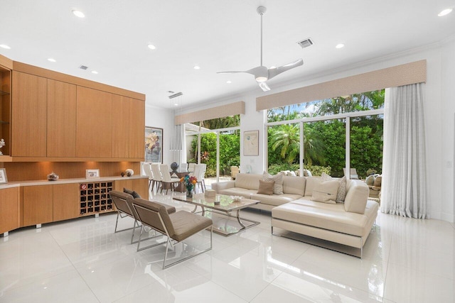 living room featuring crown molding, ceiling fan, and light tile patterned floors