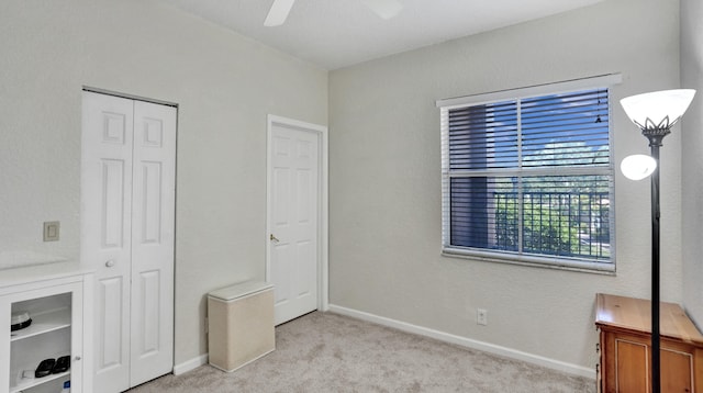 carpeted bedroom featuring ceiling fan and a closet