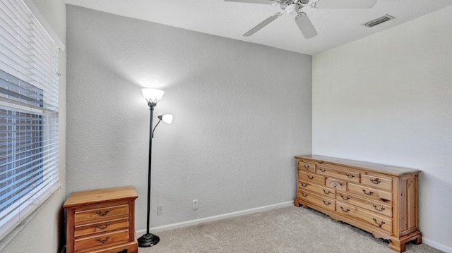 carpeted bedroom featuring multiple windows and ceiling fan