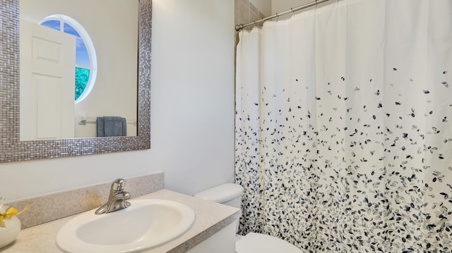 bathroom featuring a shower with shower curtain, vanity, and toilet