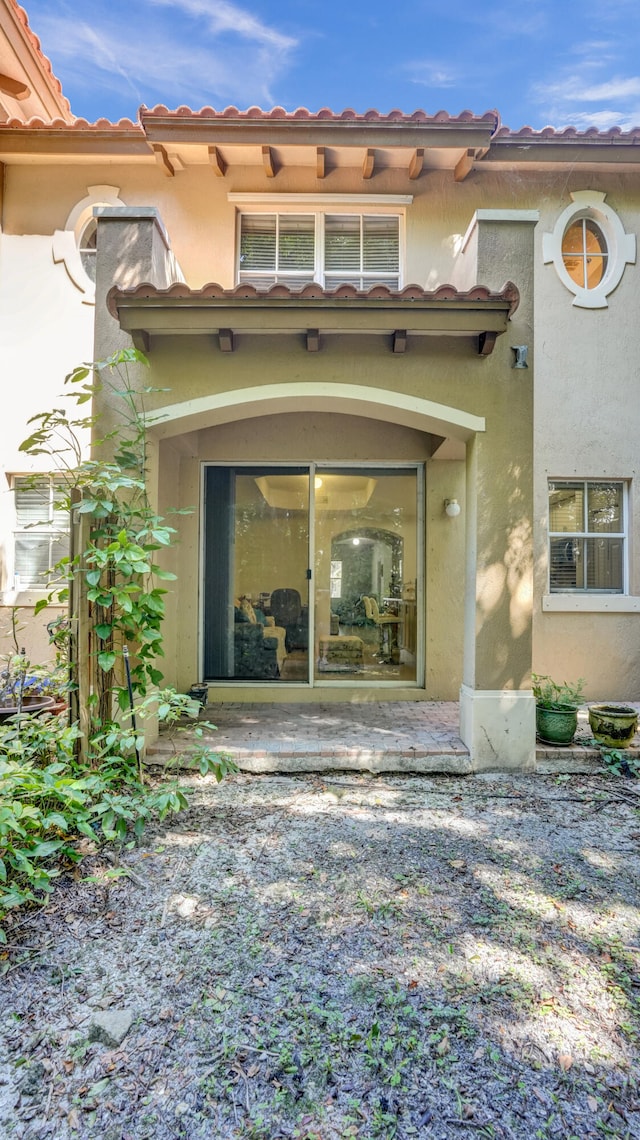 view of exterior entry with a patio area