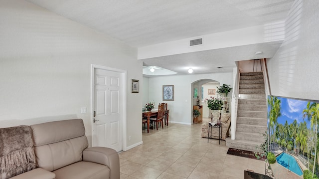 tiled living room with a textured ceiling and ceiling fan