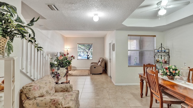 tiled foyer entrance with ceiling fan and a textured ceiling