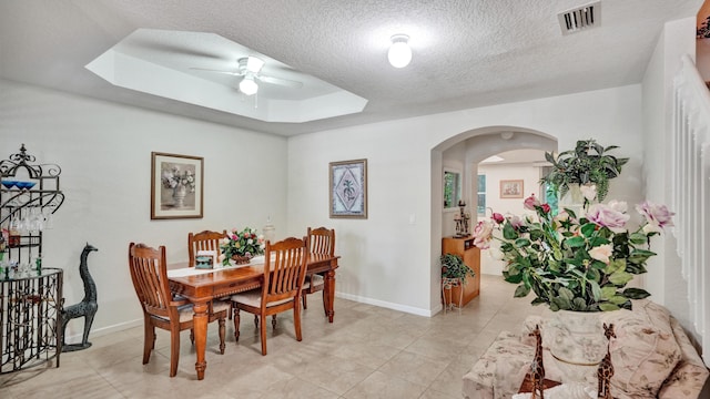 tiled dining area featuring ceiling fan and a textured ceiling