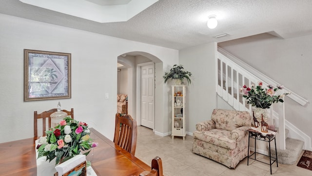 dining room with a textured ceiling and light tile patterned flooring