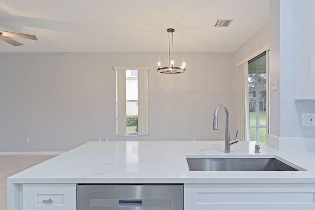 kitchen featuring white cabinetry, sink, light stone counters, and decorative light fixtures