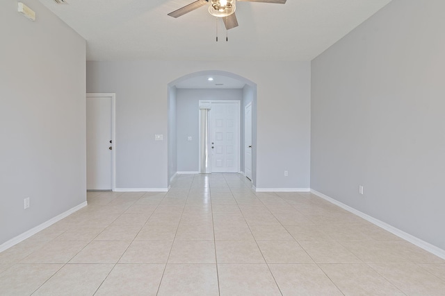 tiled spare room with ceiling fan