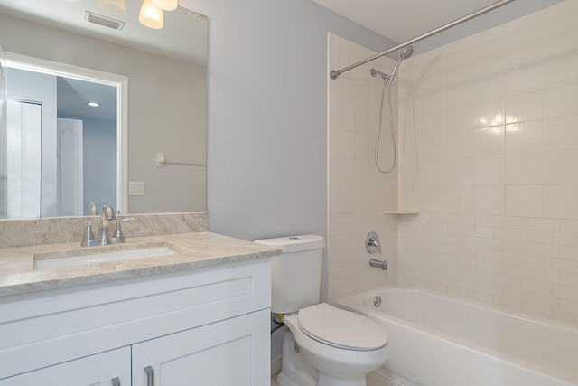 full bathroom with tiled shower / bath combo, vanity, and toilet