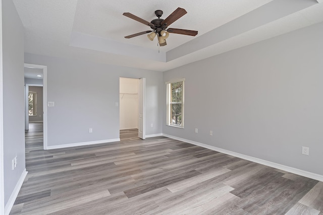 interior space with light wood-type flooring, ceiling fan, and a walk in closet