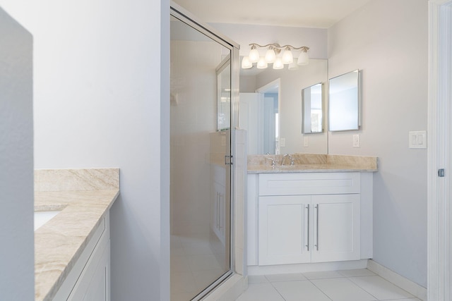 bathroom with walk in shower, vanity, and tile patterned floors