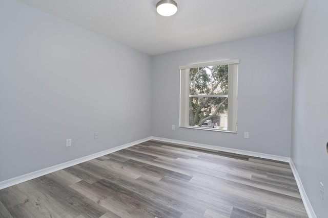 unfurnished room featuring a textured ceiling and light hardwood / wood-style floors