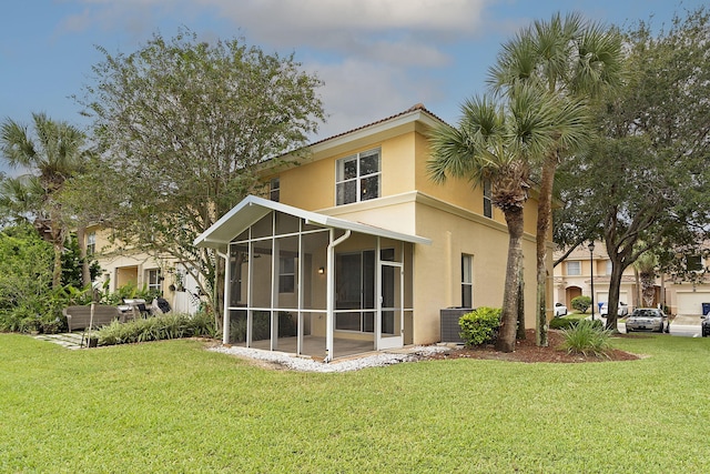 back of property with a yard and a sunroom