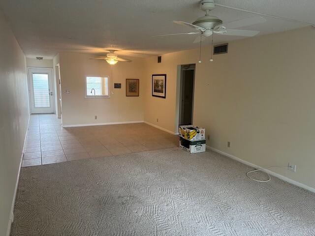 tiled spare room featuring ceiling fan