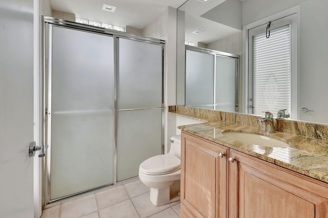 bathroom featuring tile patterned floors, vanity, toilet, and walk in shower