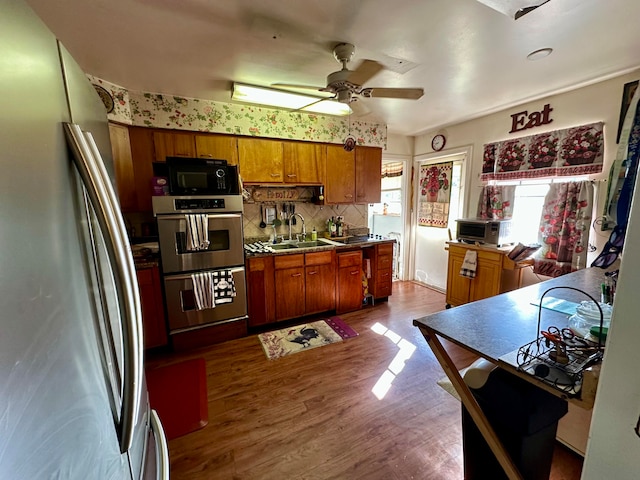 kitchen featuring sink, hardwood / wood-style flooring, ceiling fan, tasteful backsplash, and stainless steel appliances