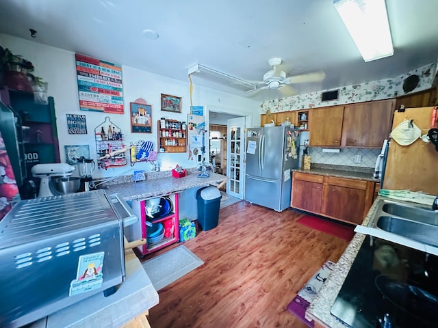 kitchen with decorative backsplash, stainless steel fridge, dark hardwood / wood-style flooring, and ceiling fan