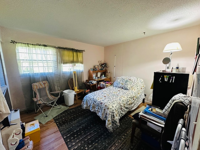 bedroom featuring hardwood / wood-style floors and a textured ceiling