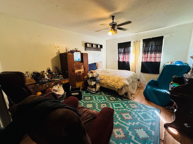 bedroom with wood-type flooring, a textured ceiling, and ceiling fan