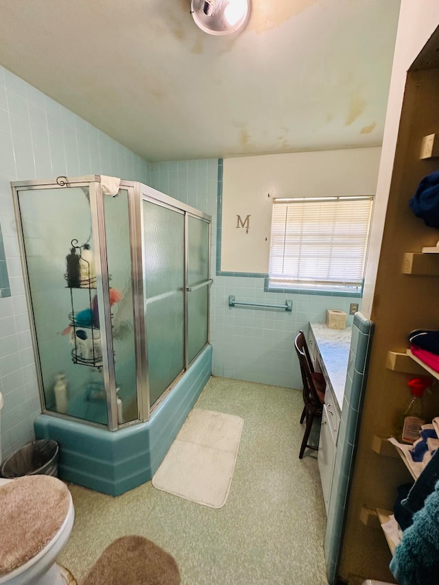 bathroom featuring vanity, toilet, and tile walls