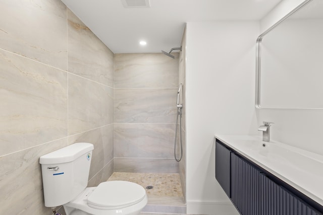 bathroom with tile walls, a shower, vanity, and toilet