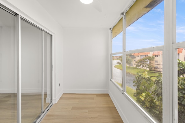 unfurnished sunroom with ceiling fan