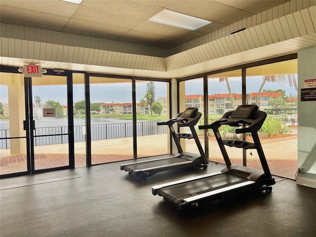 workout area featuring a wall of windows and a paneled ceiling