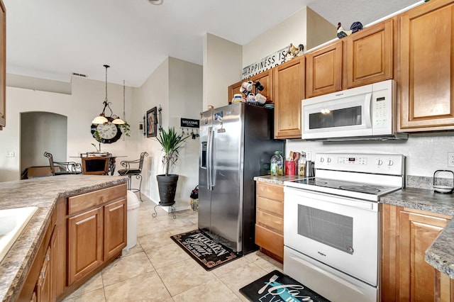 kitchen with pendant lighting, white appliances, and light tile patterned floors