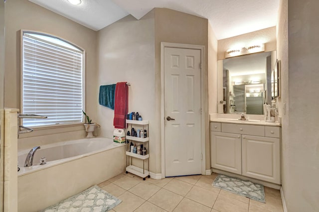 bathroom featuring vanity, a textured ceiling, a washtub, and tile patterned floors