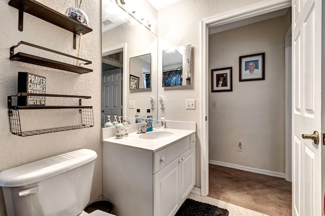 bathroom with tile patterned flooring, vanity, and toilet