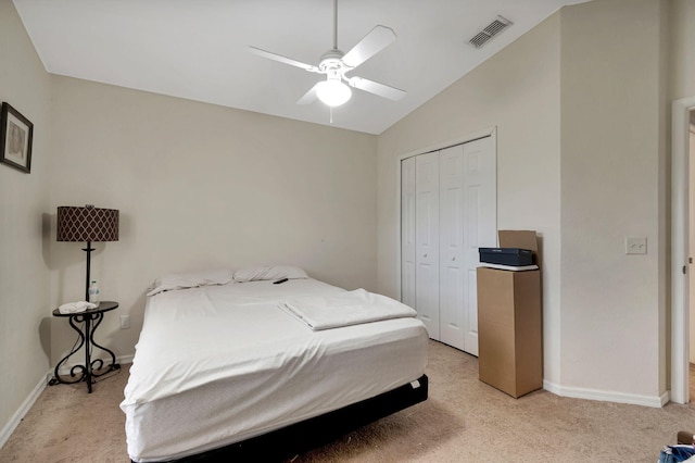 bedroom with light carpet, a closet, lofted ceiling, and ceiling fan