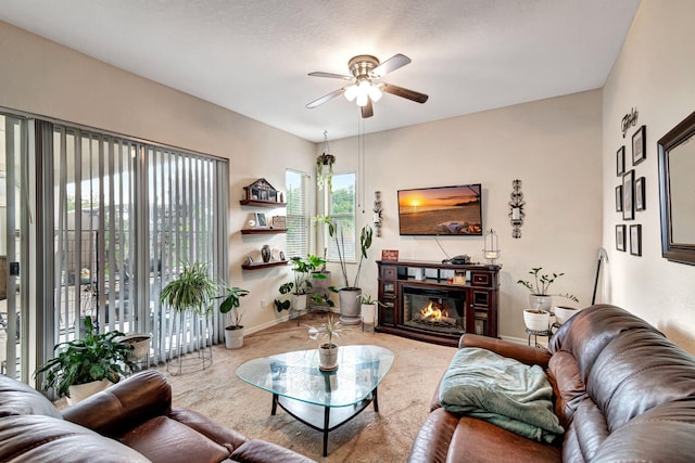 living room featuring ceiling fan and a textured ceiling