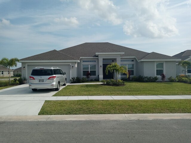 single story home with a front yard and a garage