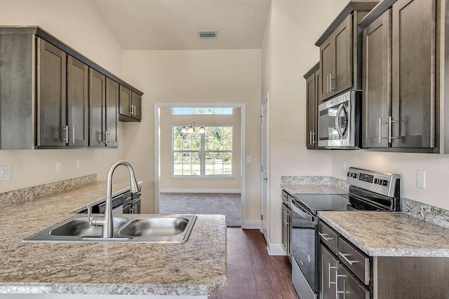 kitchen featuring light countertops, visible vents, appliances with stainless steel finishes, a sink, and dark brown cabinets