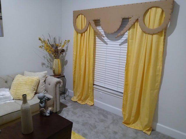 living area featuring carpet flooring and baseboards