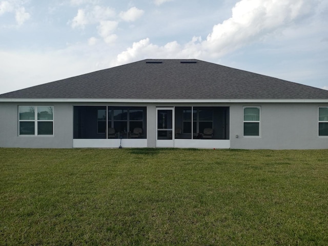 back of house with roof with shingles, a lawn, and a sunroom