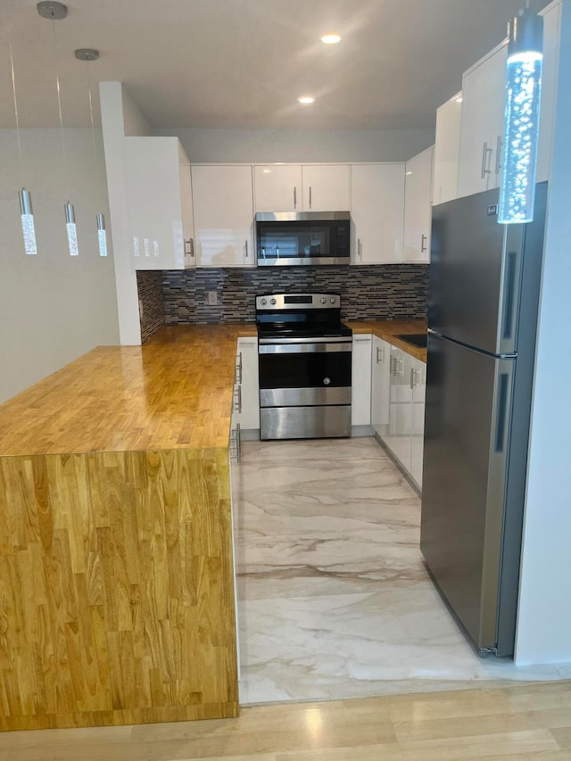 kitchen with tasteful backsplash, white cabinetry, light hardwood / wood-style flooring, and stainless steel appliances