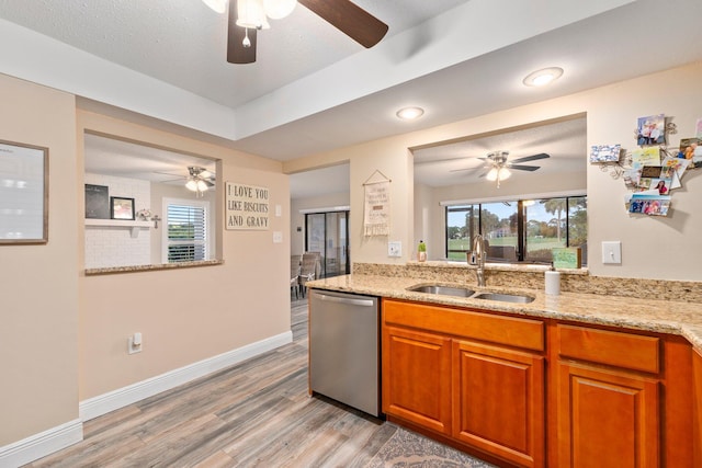 3500 Twin Lakes Ter Unit 106, Fort Pierce, FL 34951 - kitchen with dishwasher, brown cabinetry, ceiling fan, a sink, and light wood-style floors