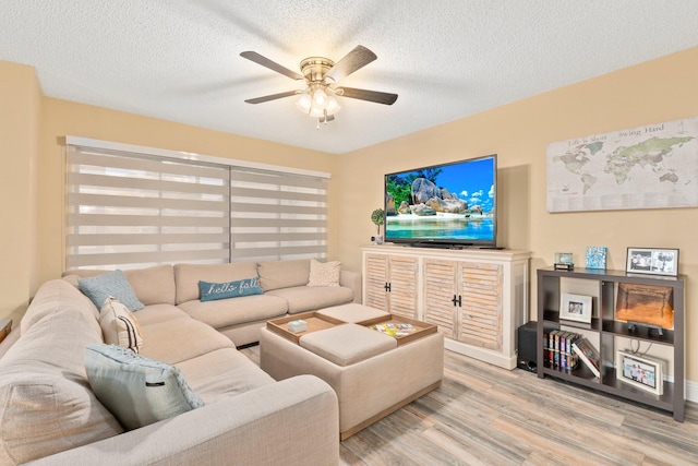 living room with a textured ceiling, hardwood / wood-style floors, and ceiling fan