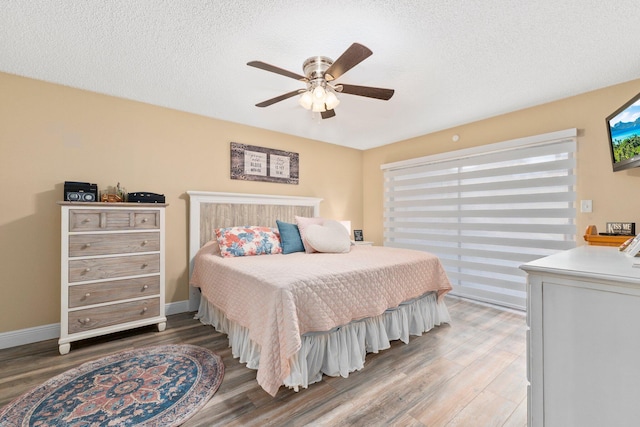 3500 Twin Lakes Ter Unit 106, Fort Pierce, FL 34951 - bedroom with baseboards, ceiling fan, a textured ceiling, and wood finished floors