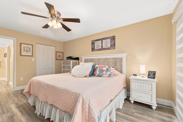 bedroom featuring ceiling fan, a closet, and dark wood-type flooring