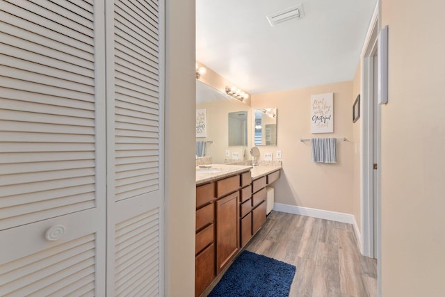 3500 Twin Lakes Ter Unit 106, Fort Pierce, FL 34951 - bathroom with a closet, wood finished floors, vanity, visible vents, and baseboards