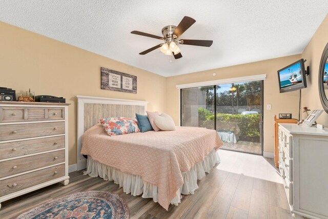 bedroom with ceiling fan, a textured ceiling, hardwood / wood-style floors, and access to exterior