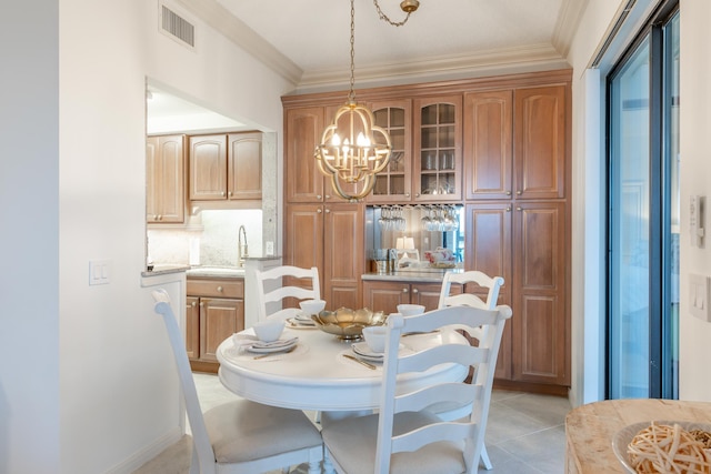 dining space featuring crown molding, light tile patterned floors, and a chandelier