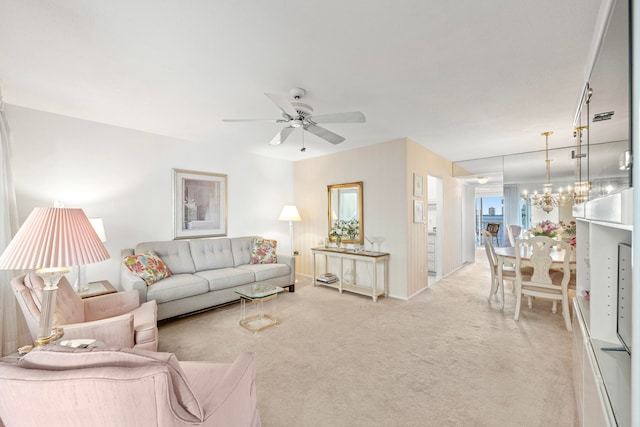 living room featuring light carpet and ceiling fan with notable chandelier