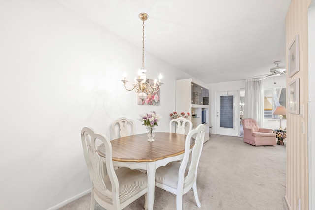 dining space featuring ceiling fan with notable chandelier and light carpet