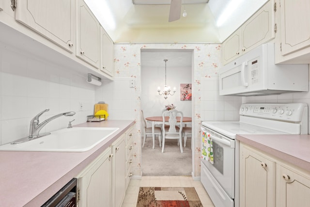 kitchen with light tile patterned flooring, sink, white appliances, tasteful backsplash, and decorative light fixtures