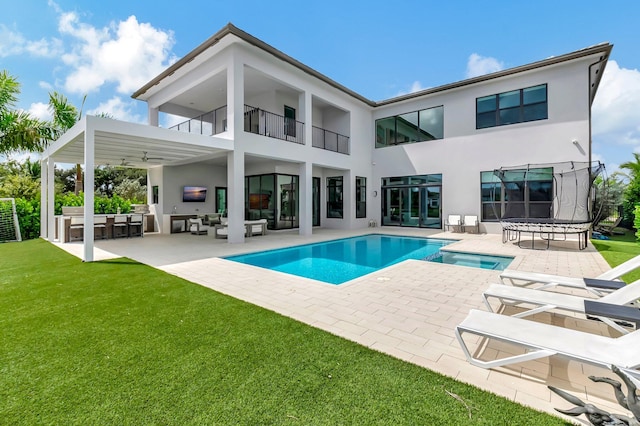 rear view of house with a balcony, outdoor lounge area, ceiling fan, a bar, and a patio