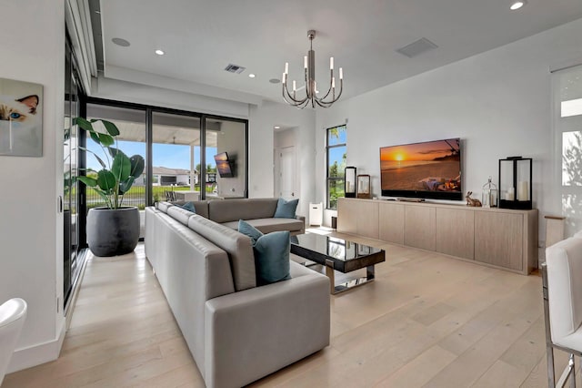 living room with light wood-type flooring and an inviting chandelier