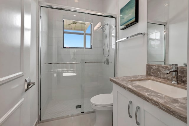 bathroom with tile patterned flooring, vanity, an enclosed shower, and toilet